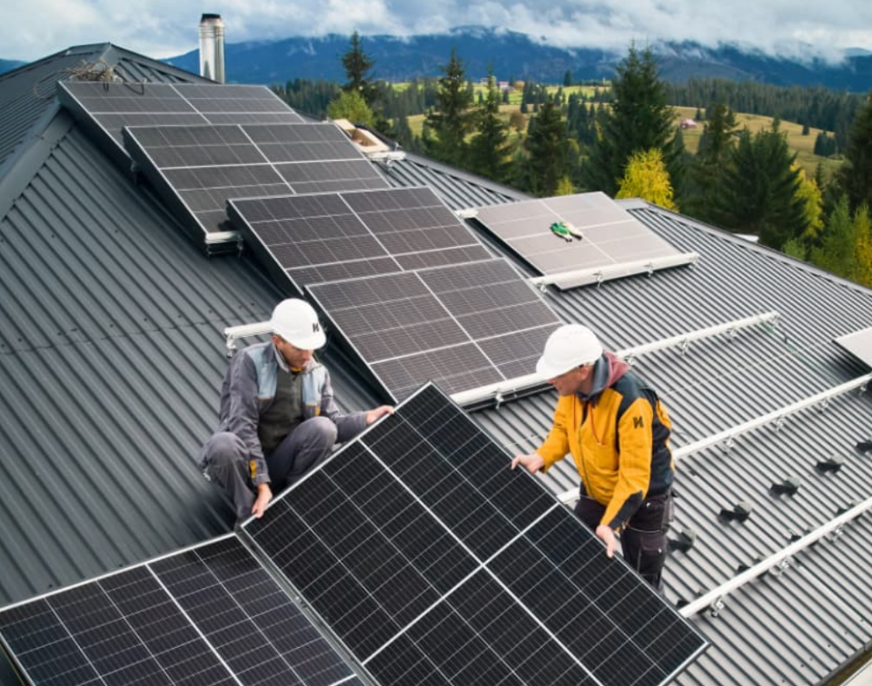 Equipo profesional instalando placas solares en un techo residencial.